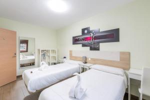 Habitación hospitalaria con 2 camas y lavamanos en OTERO&ELMA en Alovera