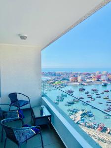 a balcony with chairs and a view of a harbor at Apartamento Alma Capital in Iquique