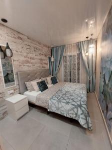 1 dormitorio con cama y pared de ladrillo en ORLANDO LUXURY APARTAMENT en Adeje