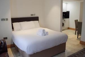 1 dormitorio con 1 cama con 2 toallas en Osborne Aparthotel en Eastbourne