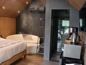 a bedroom with a bed and a coffee maker at Celeiro Lake Village - Soft Opening in São Francisco de Paula
