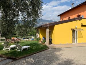 una casa amarilla con una mesa y sillas en el patio en Casa Lina en Malcesine