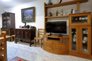 a living room with a television and a entertainment center at CASA URRA 