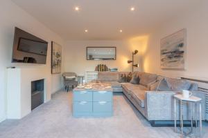 a living room with a couch and a table at Cotswold holiday let with hot tub - The Old Garage in Chipping Norton