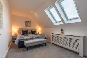 a bedroom with a bed and two skylights at Cotswold holiday let with hot tub - The Old Garage in Chipping Norton
