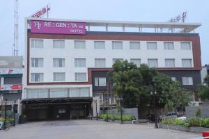 a large white building with a sign on it at Regenta Inn Morbi in Morbi