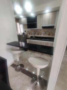Una cocina con una encimera y dos taburetes en ella. en Reserva del Peñon, en Girardot