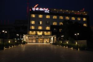 a building with a lit up sign on top of it at Regenta Inn Morbi in Morbi