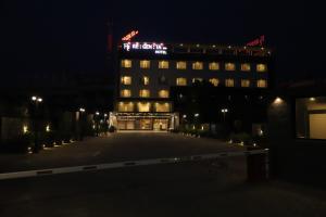 a building with a lit up sign on top at night at Regenta Inn Morbi in Morbi