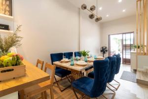 a dining room with a table and blue chairs at Naka Cozy House in Phuket City in Ban Rangeng