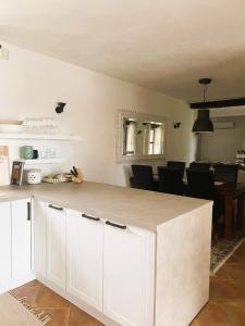cocina con armarios blancos y comedor en Villa Isabella - Ruheoase, en Poreč