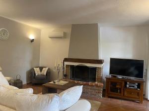 Una sala de estar con chimenea y televisión. en Villa Isabella - Ruheoase, en Poreč