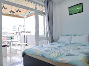 ホーチミン・シティにあるCozy studio at Hai Ba Trung st., Dist 3 near Tan Dinh marketのベッドルーム1室(ベッド1台付)、バルコニー(テーブル付)