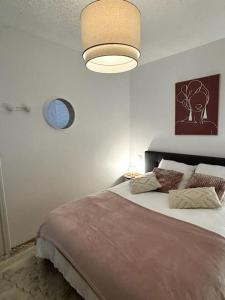 1 dormitorio con 1 cama grande y reloj en la pared en Cozy atmosphere near Eurexpo and Groupama Stadium, 6 personnes en Saint-Priest