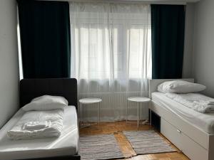 1 dormitorio con 2 camas individuales y ventana en GoetheApartment en Frankfurt