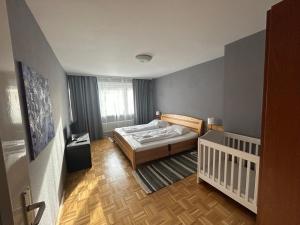 a small bedroom with a bed and a crib at GoetheApartment in Frankfurt