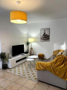 een woonkamer met een bank en een flatscreen-tv bij Cozy atmosphere near Eurexpo and Groupama Stadium, 6 personnes in Saint-Priest