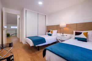a hotel room with two beds and a window at Ponta Delgada Flats - HOST & CHILL in Ponta Delgada