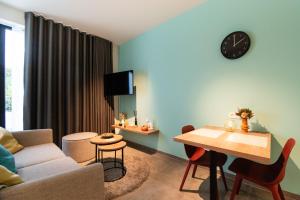 een woonkamer met een bank en een tafel bij SYBA Gastenverblijf in Evergem