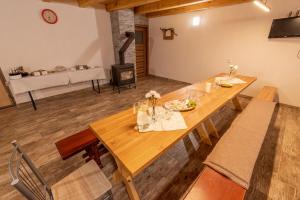 a dining room with a wooden table and a fireplace at Búda u Kramářů - penzion Robin in Mutěnice