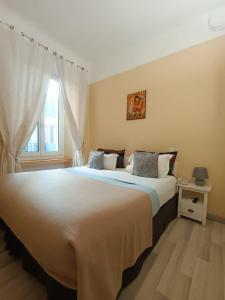 a bedroom with a large white bed with a window at Hotel Villa La Tour in Nice
