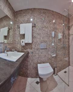 uma casa de banho com um lavatório, um WC e um chuveiro em Arena Mar Hotel and SPA em Golden Sands