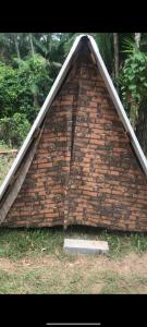 un edificio con techo triangular en la hierba en Camping Toninhas, en Ubatuba