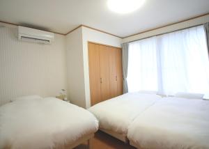 two beds in a room with a window at たび宿SeKKoku in Takagi