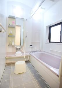 a bathroom with a tub and a toilet and a sink at たび宿SeKKoku in Takagi