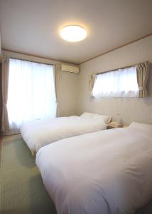 Habitación de hotel con 2 camas y ventana en たび宿SeKKoku en Takagi