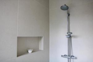 a shower with a light and a shelf in a bathroom at Spacious apartment with garden in Amsterdam