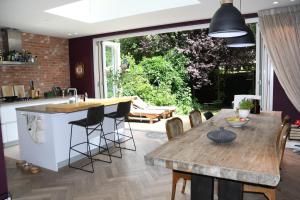een keuken en eetkamer met een houten tafel bij Spacious apartment with garden in Amsterdam