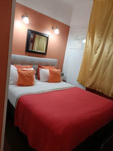 - une chambre avec un lit et une couverture rouge dans l'établissement Hotel Villa La Tour, à Nice