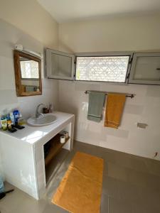 baño con lavabo, espejo y ventana en Villa Saraba, en Somone