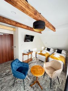 1 dormitorio con 2 camas y silla azul en ApartHotel Centrum - parking free, en Białystok