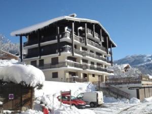 un edificio cubierto de nieve con un camión delante en Appartement Notre-Dame-de-Bellecombe, 2 pièces, 6 personnes - FR-1-595-20 en Notre-Dame-de-Bellecombe