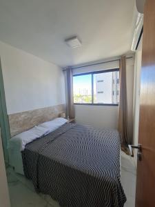 una camera da letto con un letto e una grande finestra di Apartamento em boa viagem a Recife