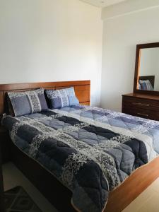 1 dormitorio con 1 cama grande y cabecero de madera en Apparemment avec piscine, en Kenitra