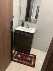W łazience znajduje się umywalka, lustro i dywan. w obiekcie Apparemment avec piscine w mieście Kenitra