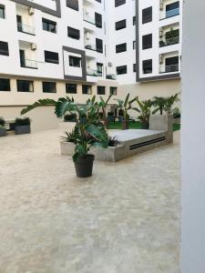 Apparemment avec piscine في القنيطرة: مبنى كبير مع نباتات الفخار في ساحة الفناء