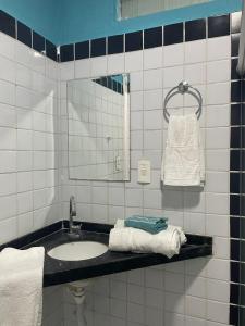 uma casa de banho com lavatório, espelho e toalhas em Casa São bento 193 em Olinda
