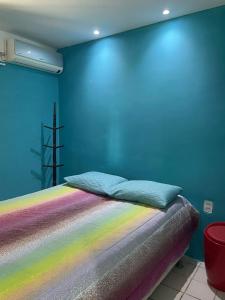 1 dormitorio con cama de arco iris y pared azul en Casa São bento 193, en Olinda