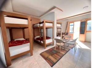 a room with four bunk beds and a table and chairs at Seaview Hotel Dahab in Dahab