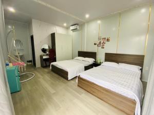 a hotel room with two beds and a bathroom at Happy House in Buôn Ea Yông