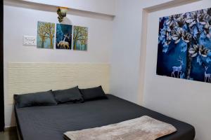 新孟買的住宿－Zoey's Hill View，墙上有两幅画作的房间的一张床位