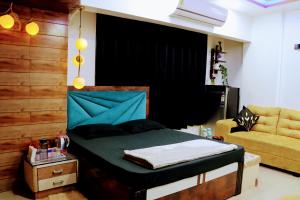 ein Schlafzimmer mit einem Bett und einem Sofa in der Unterkunft Zoey's Hill View - 120" 4K Projection Cinema, Jacuzzi, Party Up in Navi Mumbai