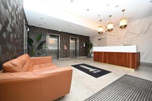 a lobby with a couch and a reception desk at The Obel in Belfast