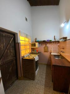 cocina con fregadero y fogones horno superior en Complejo Quimey alojamiento familiar en Villa Gesell