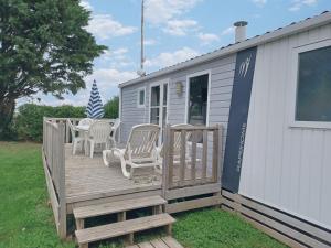 a large deck with two chairs and a table at Mobil home équipé camping 5* in Houlgate