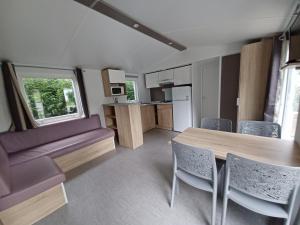 a kitchen and dining room with a table and chairs at Mobil home équipé camping 5* in Houlgate